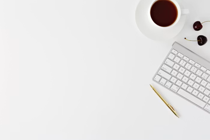 A keyboard resting beside a mug and a click pen
