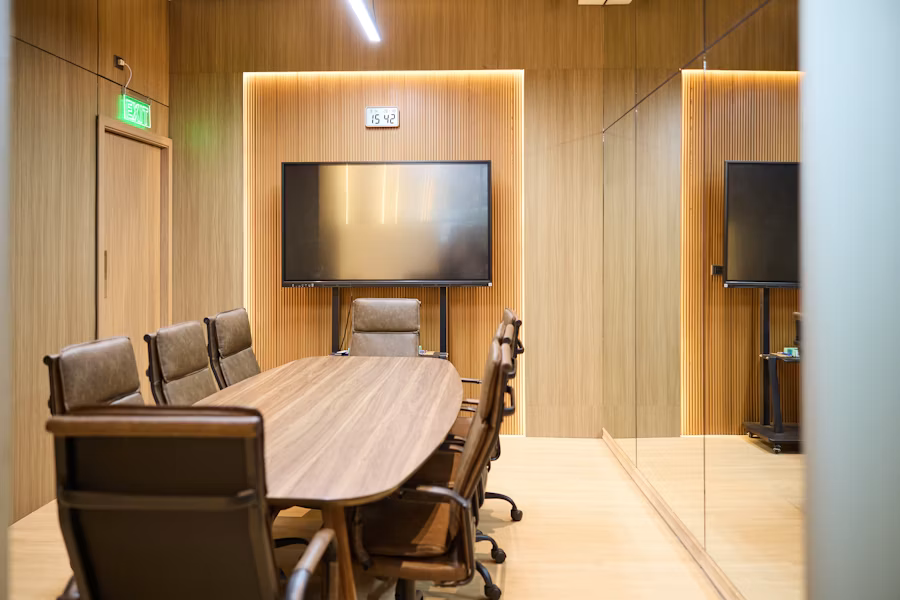 A modern conference room with an oval table and comfortable chairs