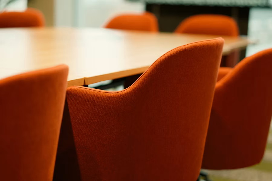 Orange chairs arranged around a wooden conference table