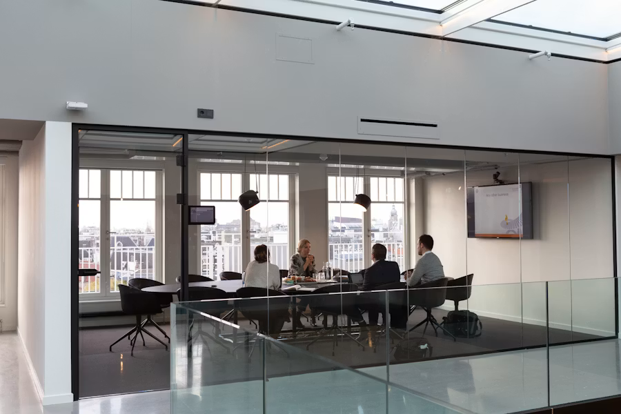 People seated together inside a bright modern building reviewing plans