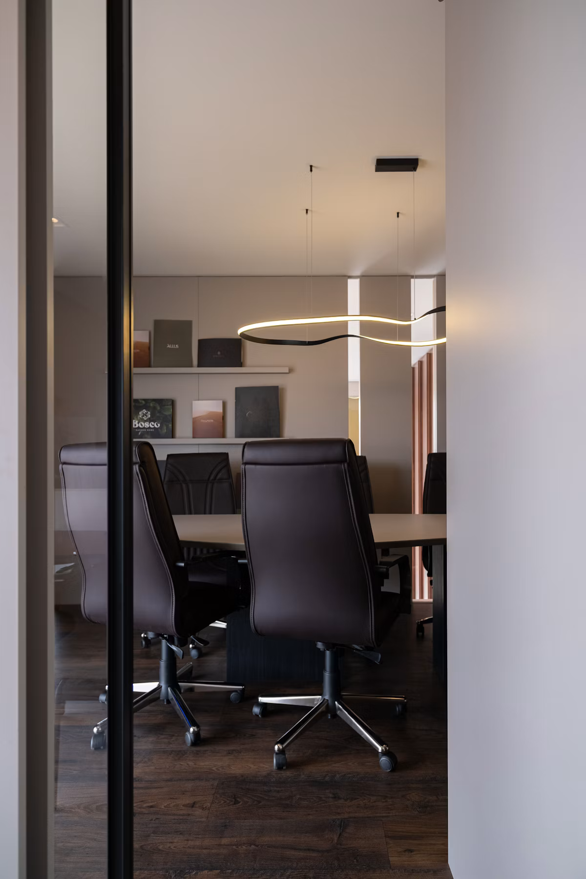 A modern conference room furnished with leather chairs around a long table